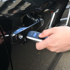 リモコンキーで車のドアを開ける様子